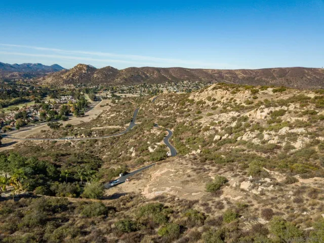 an aerial view of houses with yard and mountain view in back