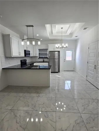 a kitchen with stainless steel appliances a sink a counter top space cabinets and a window