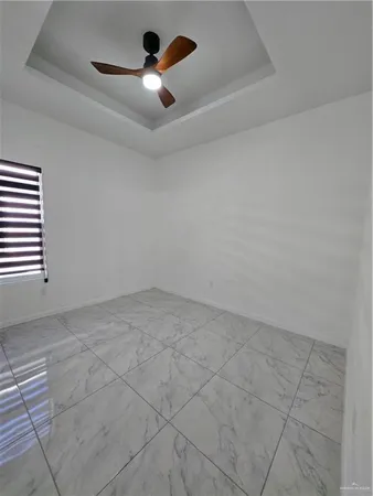 an empty room with windows and fan