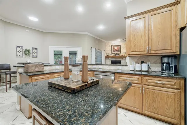 a large kitchen with granite countertop a stove a sink a dining table and chairs