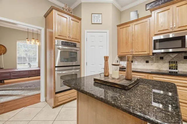 a kitchen with kitchen island granite countertop a sink and cabinets