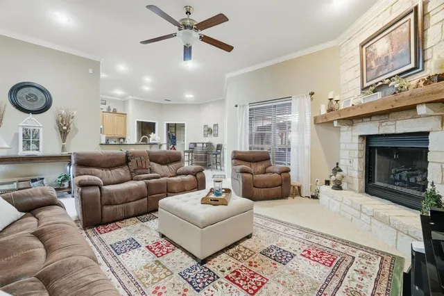 a living room with furniture a fireplace and a large window