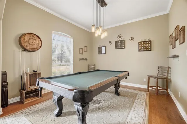 a room with pool table and windows
