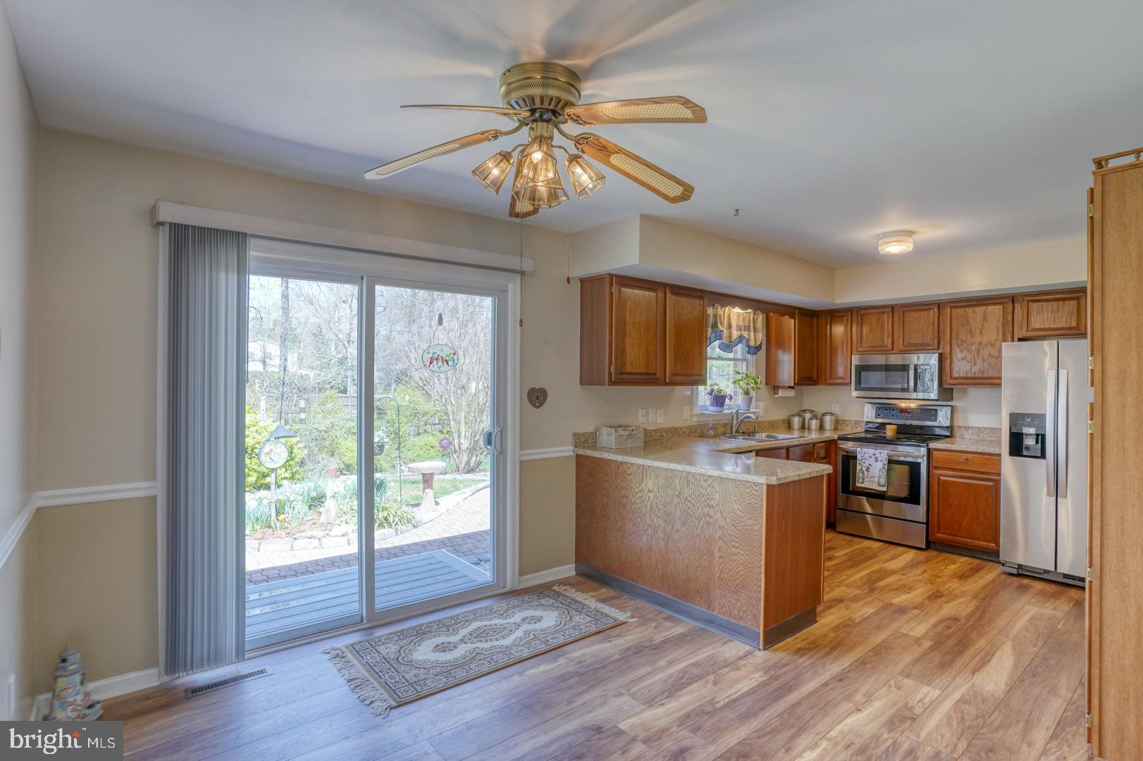 20 Tammie Drive Bear, DE 19701 - Photo 16 of 37 a kitchen with stainless steel appliances granite countertop a refrigerator a stove top oven a chimney cabinets and wooden floor