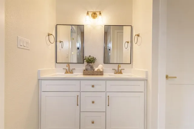 a bathroom with double sink and a mirror