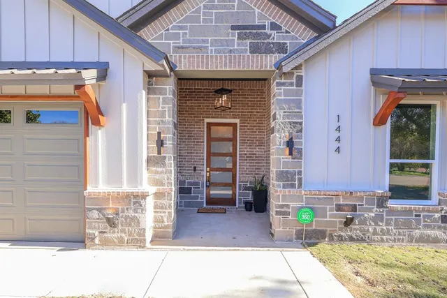 a front view of a house with barbeque and wooden floor