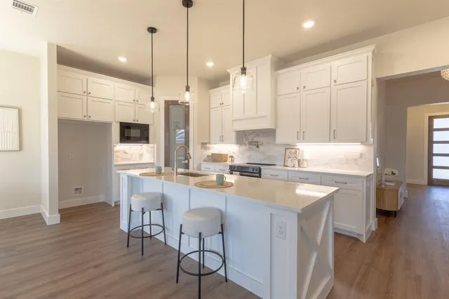 a kitchen with white cabinets and stainless steel appliances