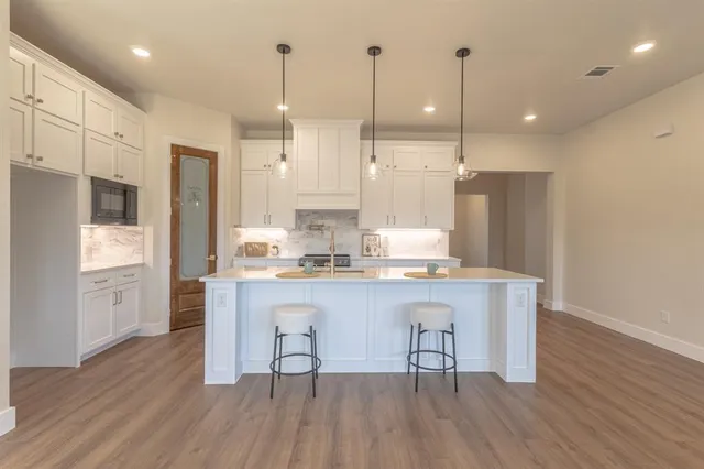 a kitchen with stainless steel appliances granite countertop a refrigerator a sink and a stove