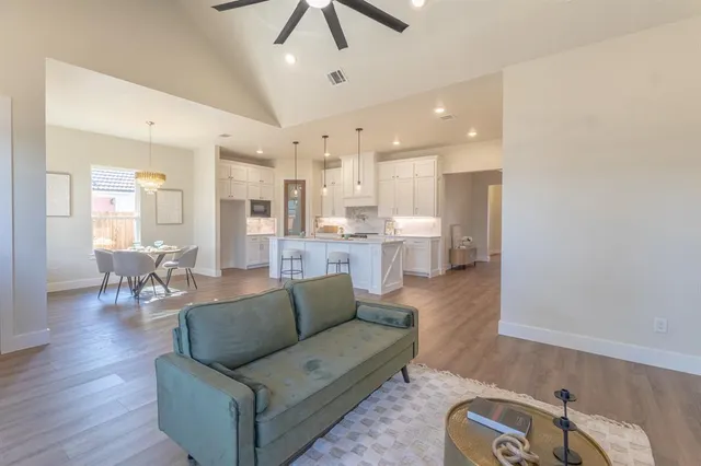 a living room with furniture kitchen view and a chandelier
