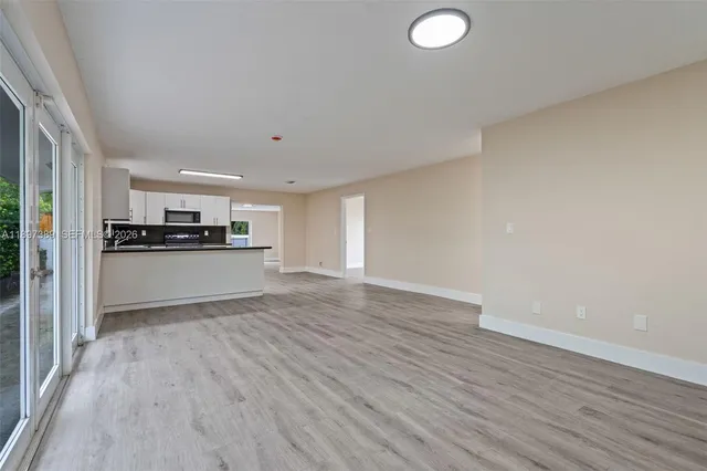 a view of a kitchen with wooden floor and electronic appliances