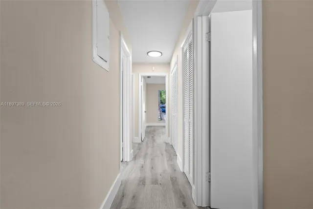 a view of a room that has wooden floor and a window