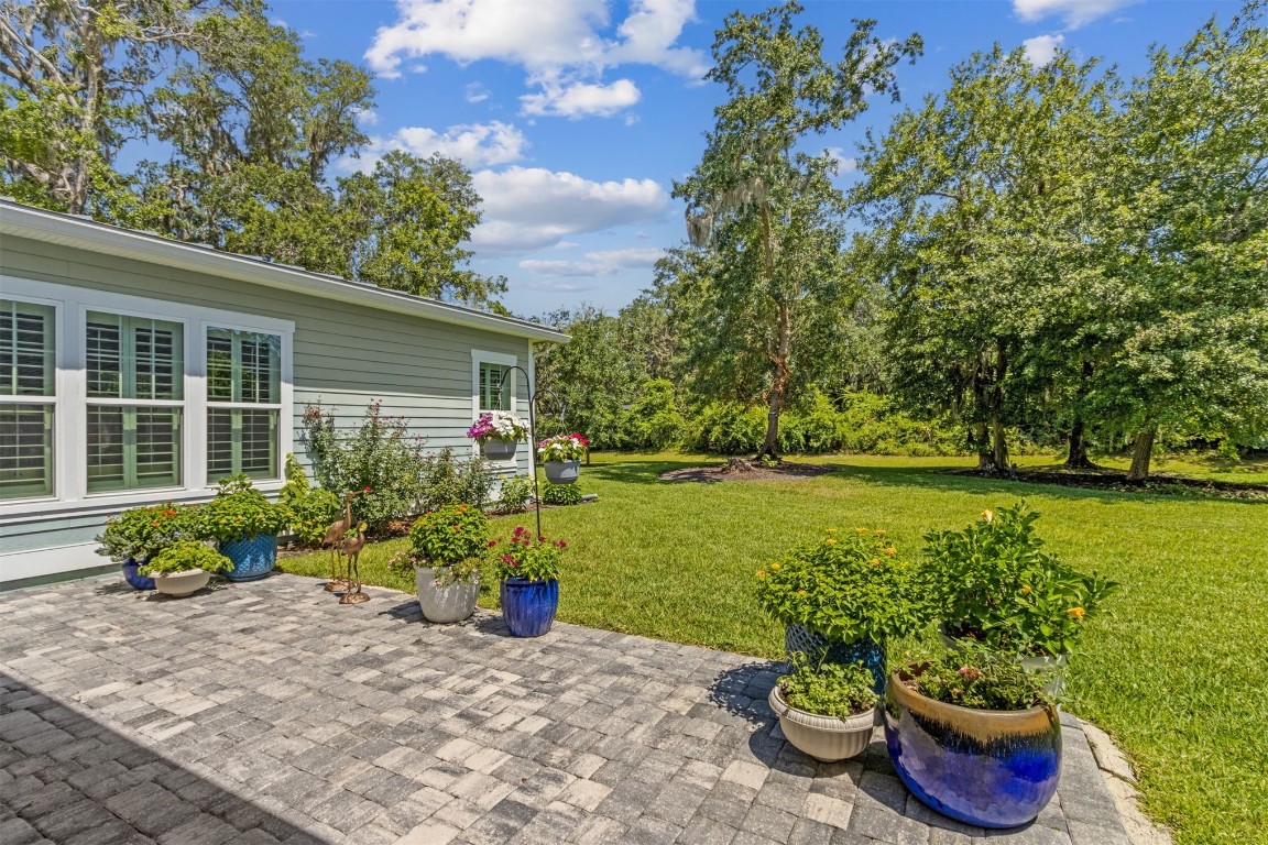 2930 Riverbend Walk Fernandina Beach, FL 32034 - Photo 54 of 60 a garden with a bench in front of the house