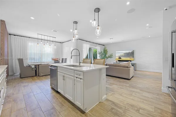 a large kitchen with cabinets wooden floor and stainless steel appliances