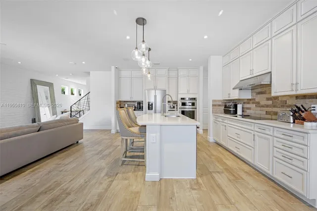 a kitchen with cabinets and chairs