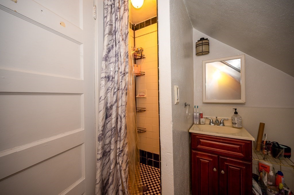 12 Prescott Street Springfield, MA 01108 - Photo 8 of 39 a bathroom with a sink a mirror and a shower