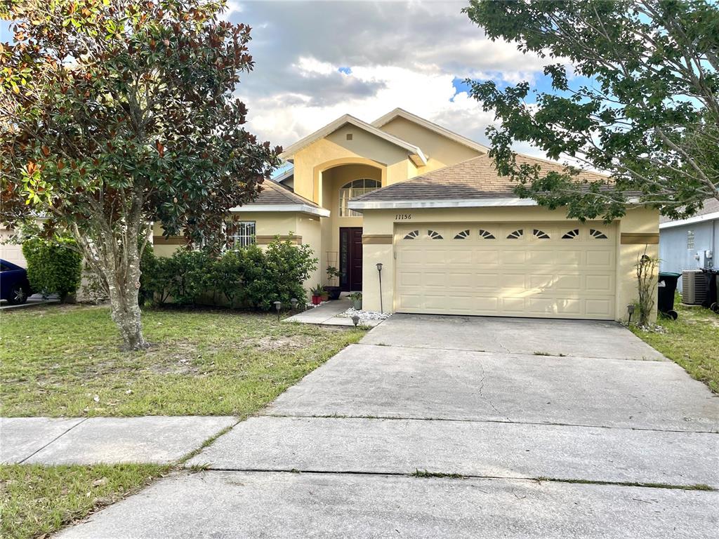 11156 Rouse Run Circle Orlando, FL 32817 - Photo 1 of 15 a front view of a house with a garden and trees