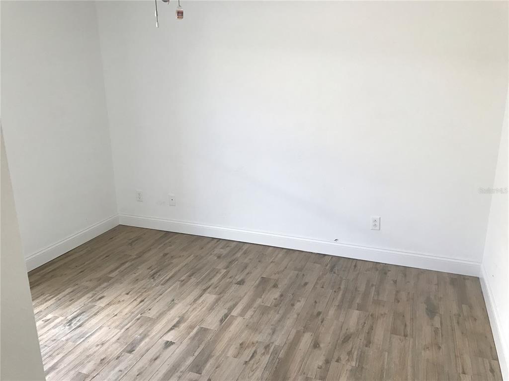 11156 Rouse Run Circle Orlando, FL 32817 - Photo 12 of 15 a view of an empty room with wooden floor and a window