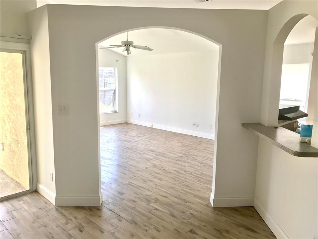 11156 Rouse Run Circle Orlando, FL 32817 - Photo 4 of 15 an empty room with wooden floor and windows