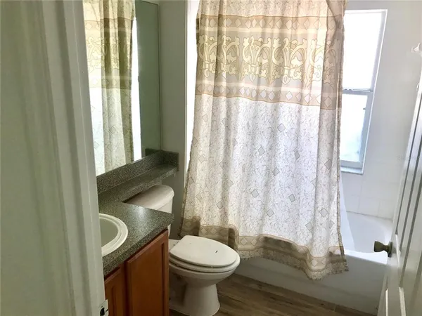 a bathroom with a toilet a sink and a shower curtain