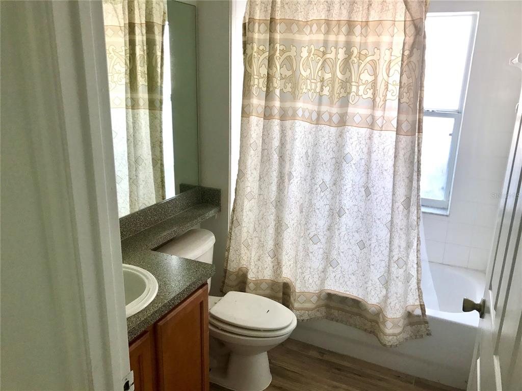 11156 Rouse Run Circle Orlando, FL 32817 - Photo 5 of 15 a bathroom with a toilet a sink and a shower curtain