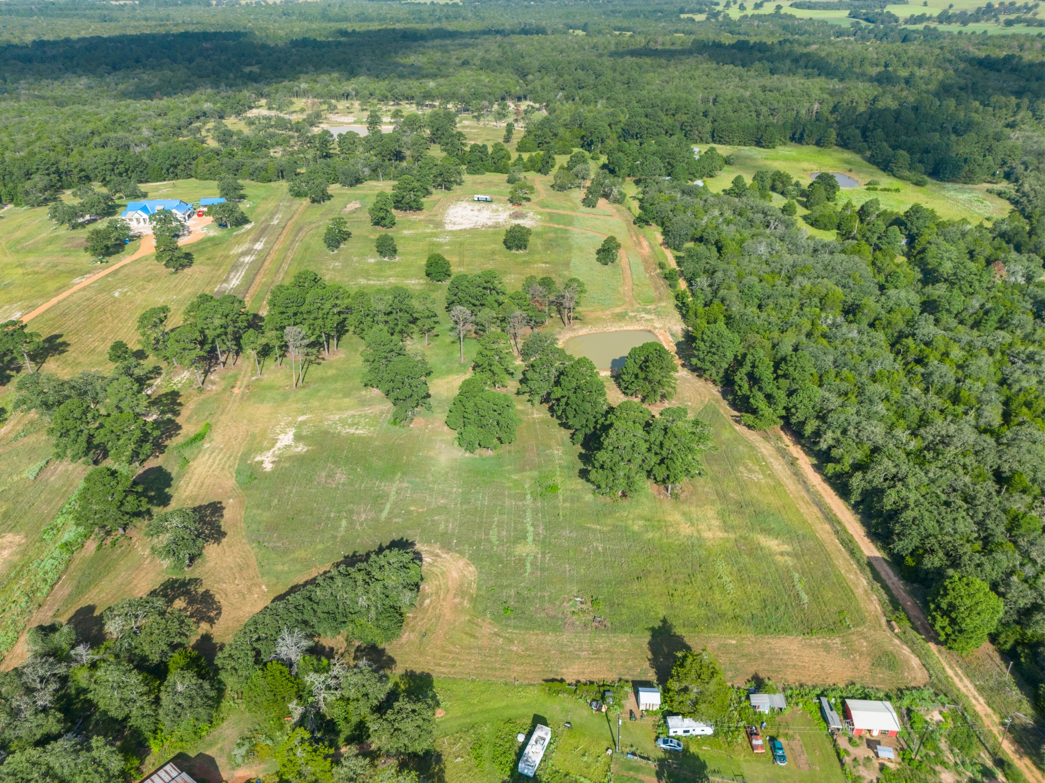 170 Split Oak Road Smithville, TX 78957 - Photo 3 of 31 An aerial perspective reveals sprawling, well-maintained acreage bordered by dense woodlands and featuring multiple ponds.