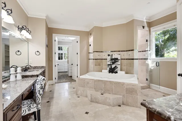 a spacious bathroom with a granite countertop sink a mirror and a bathtub