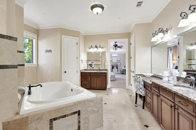 a spacious bathroom with a granite countertop sink a mirror a bathtub and shower