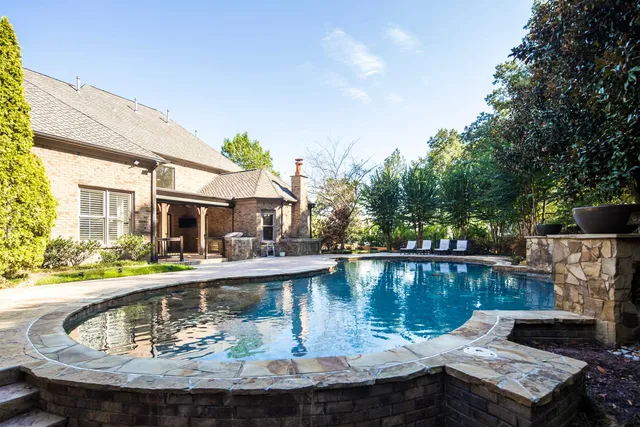 a view of house with swimming pool and outdoor seating
