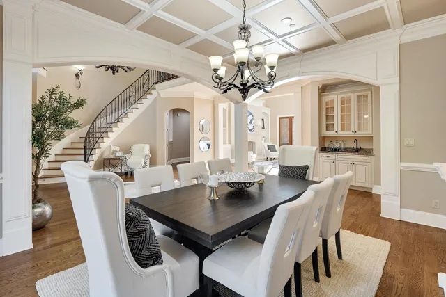 a view of a dining room with furniture a chandelier and wooden floor