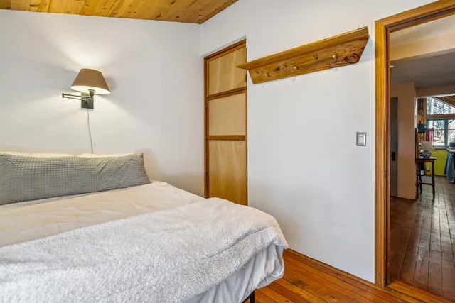 a bedroom with a bed and a painting on the wall