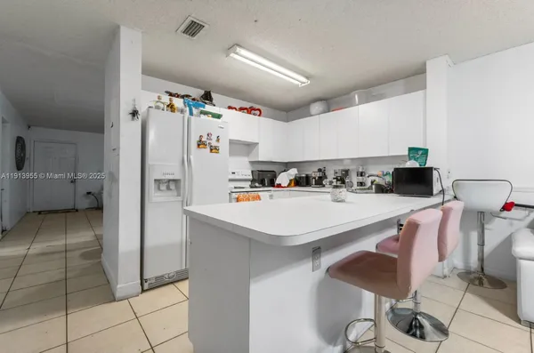 a kitchen with stainless steel appliances a refrigerator and a stove top oven