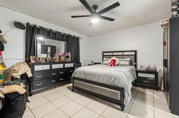 a bedroom with a bed and a large mirror on the dresser