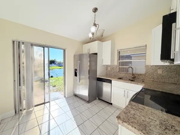 a kitchen with stainless steel appliances granite countertop a refrigerator and a sink
