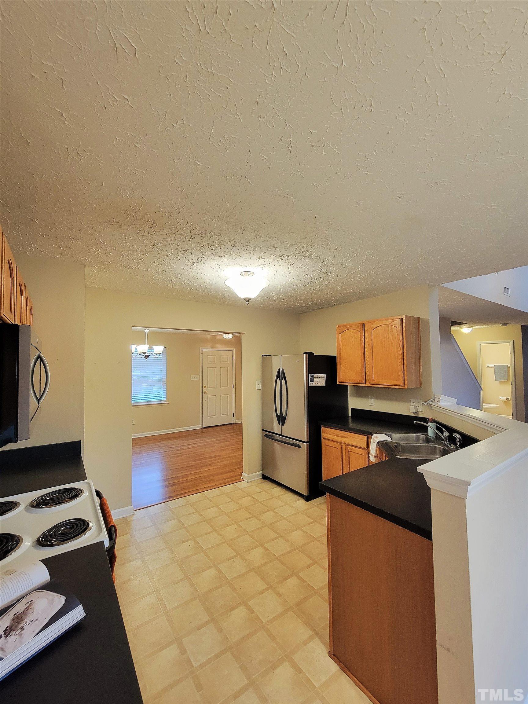 4237 Palafox Court Raleigh, NC 27604 - Photo 3 of 20 a kitchen with a stove a sink and a refrigerator