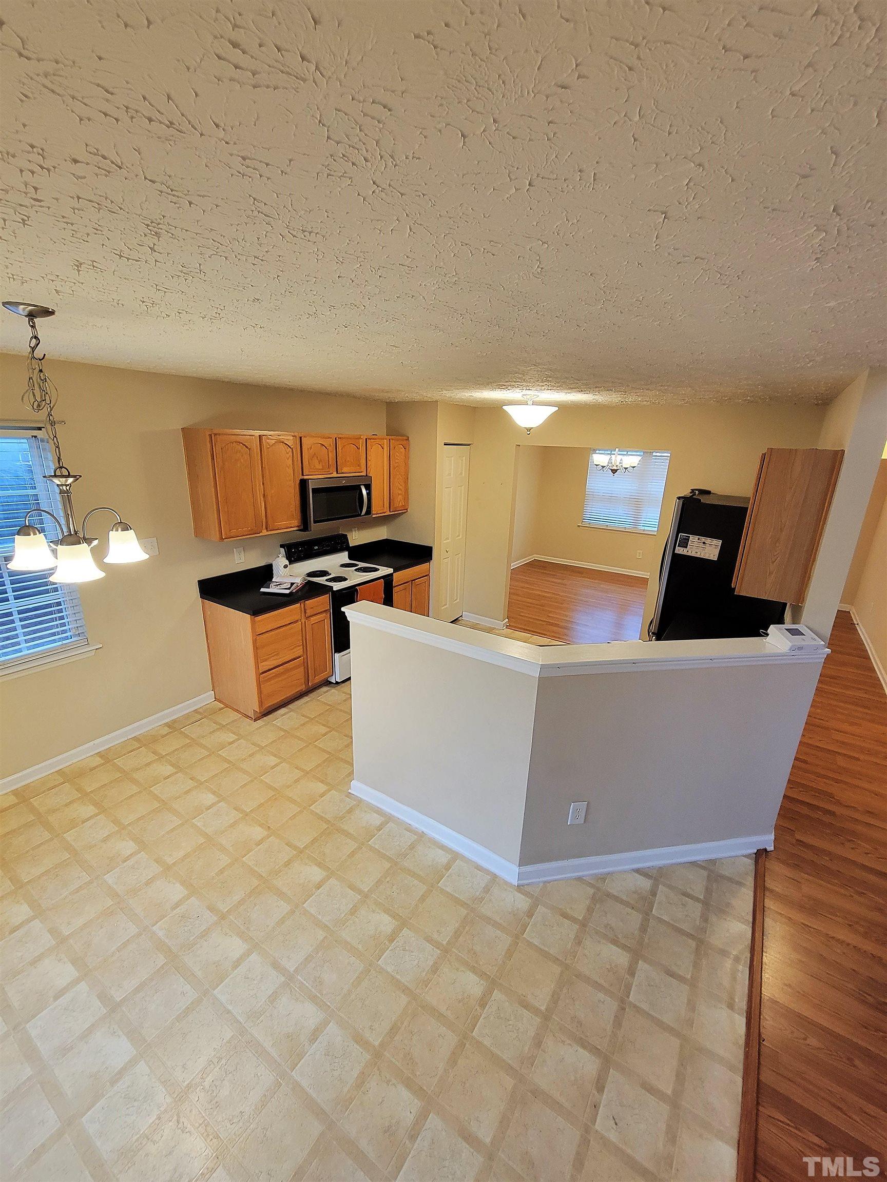 4237 Palafox Court Raleigh, NC 27604 - Photo 5 of 20 a kitchen with stainless steel appliances a stove a sink a refrigerator and cabinets
