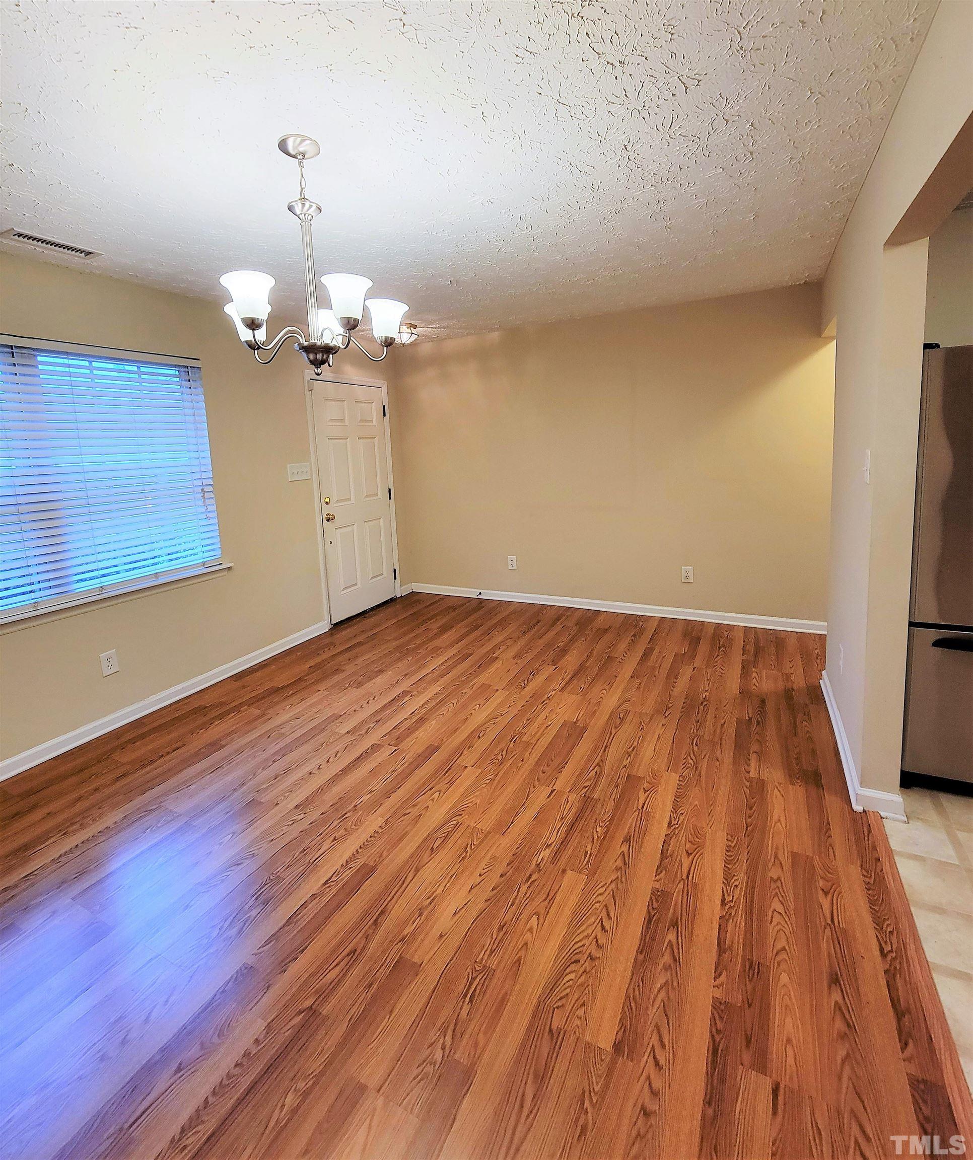 4237 Palafox Court Raleigh, NC 27604 - Photo 8 of 20 a view of a room with wooden floor staircase and a kitchen