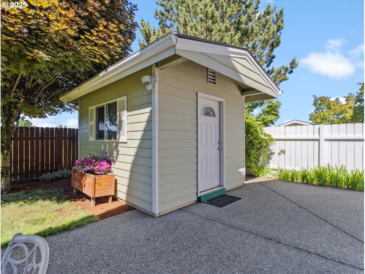 863 June Drive Molalla, OR 97038 - Photo 31 of 36 a blue and white house with a small yard plants and wooden fence