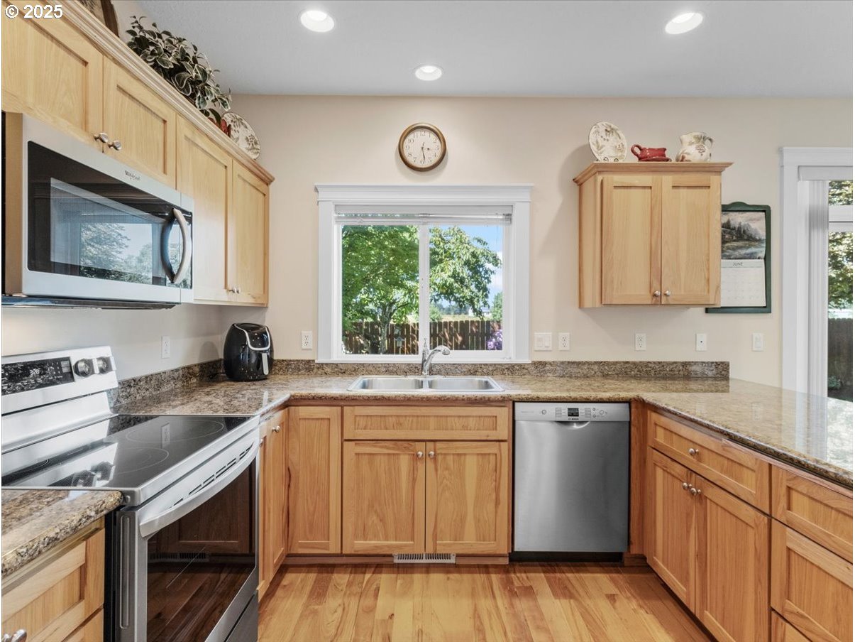 863 June Drive Molalla, OR 97038 - Photo 5 of 36 a kitchen with granite countertop cabinets stainless steel appliances a sink and a window