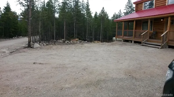 a backyard of a house with barbeque oven and trees
