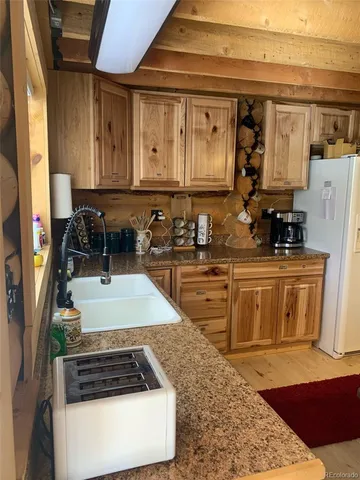 a kitchen with a table chairs and refrigerator
