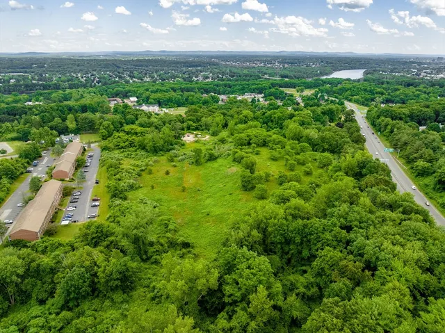 an aerial view of residential houses with outdoor space and trees
