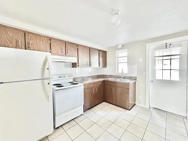 a kitchen with a refrigerator sink and cabinets