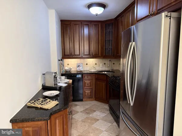 a kitchen with stainless steel appliances granite countertop a refrigerator and a stove