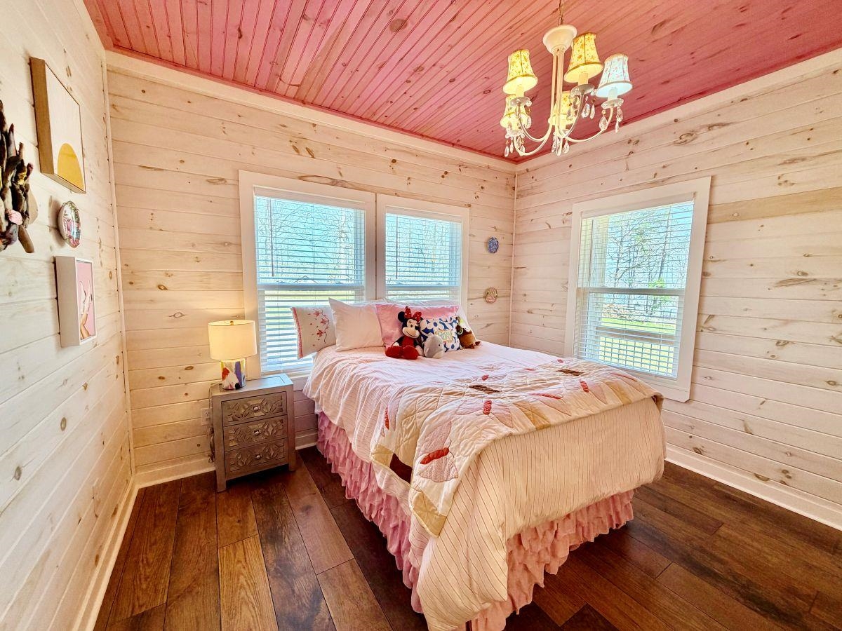 540 Muscatel Lane Counce, TN 38326 - Photo 16 of 32 a bedroom with a bed chandelier and a window