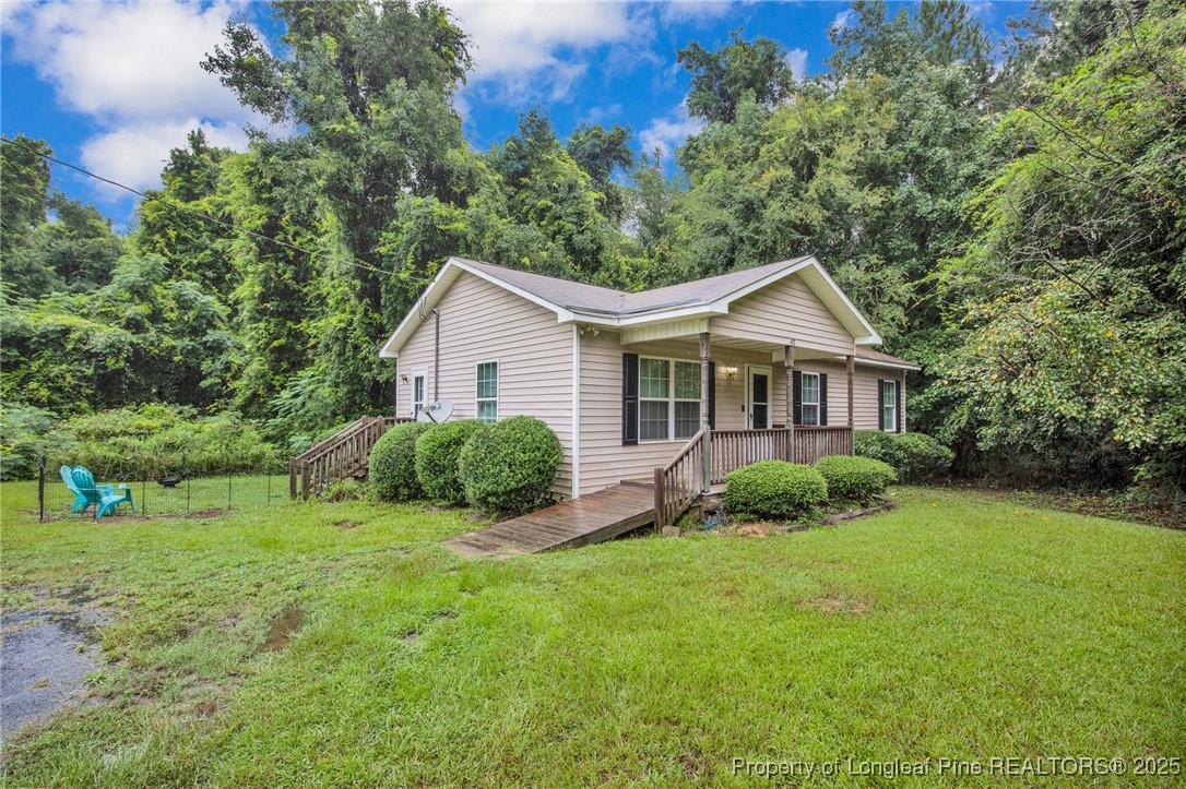 112 Madison Road Carthage, NC 28327 - Photo 2 of 27 a view of a house with a big yard potted plants and large tree