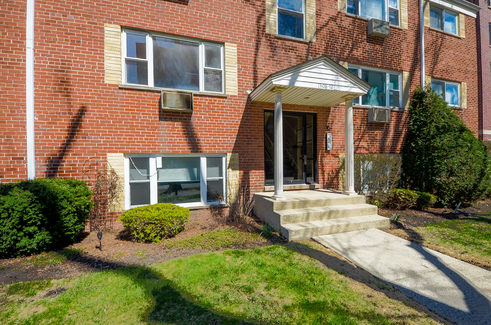 front view of a brick house with a yard