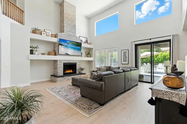a living room with furniture a flat screen tv and a fireplace
