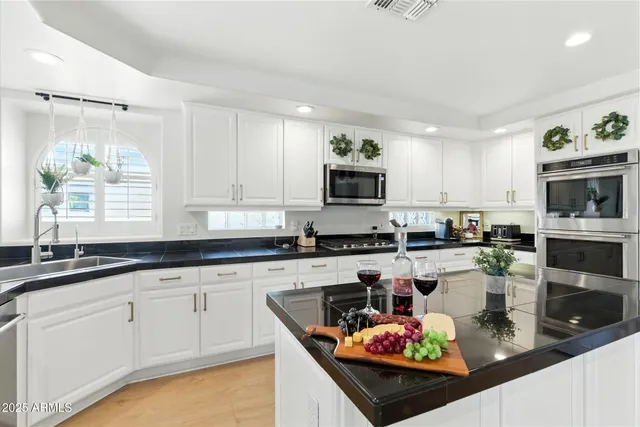 a kitchen with stainless steel appliances granite countertop a sink a stove counter space and cabinets