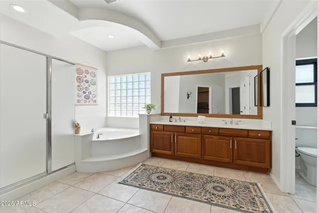 a spacious bathroom with a tub sink and mirror
