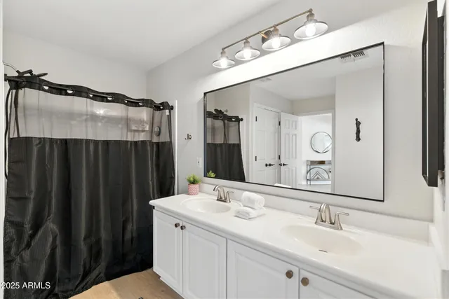 a spacious bedroom with a bed and a chandelier
